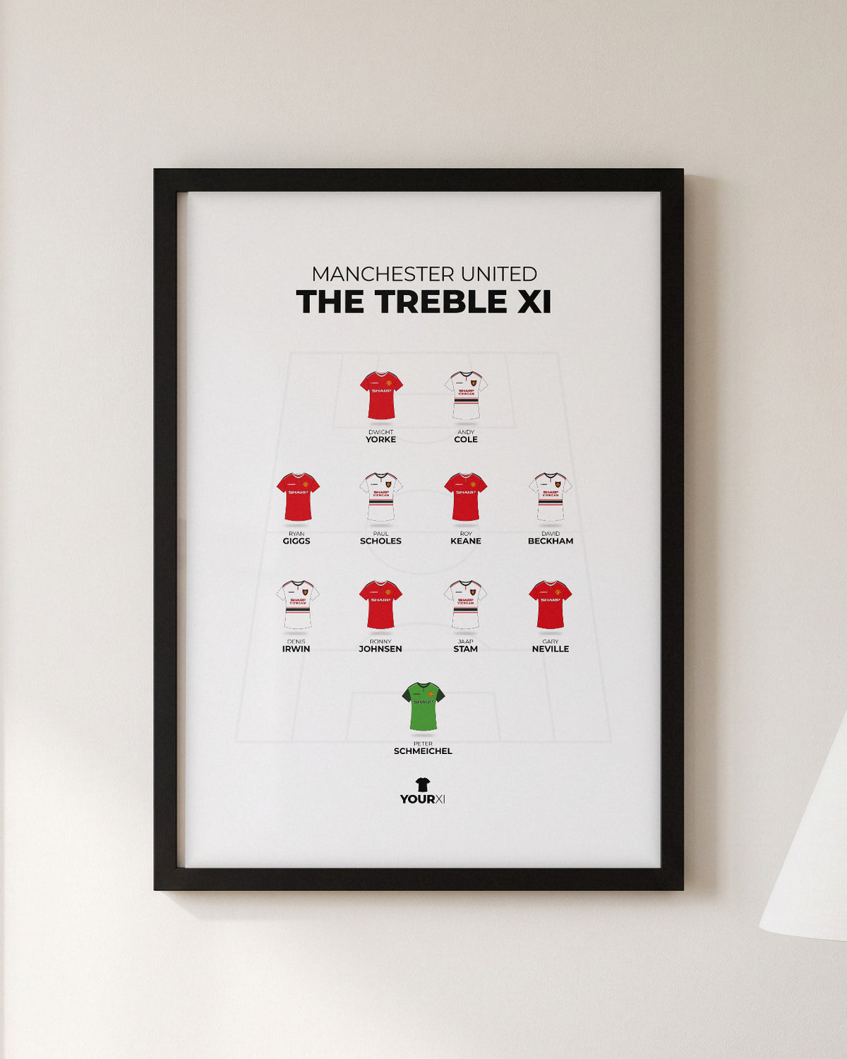 Manchester United Treble XI framed print, black frame on a wall